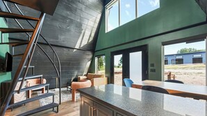 Uma cozinha moderna com bancada de granito, escada e vista para o exterior.