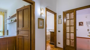 A hallway with wooden flooring, a wooden door, and a mirror on the wall. - Beautiful apartment for 5 guests with WIFI, TV and patio (Greve In Chianti)