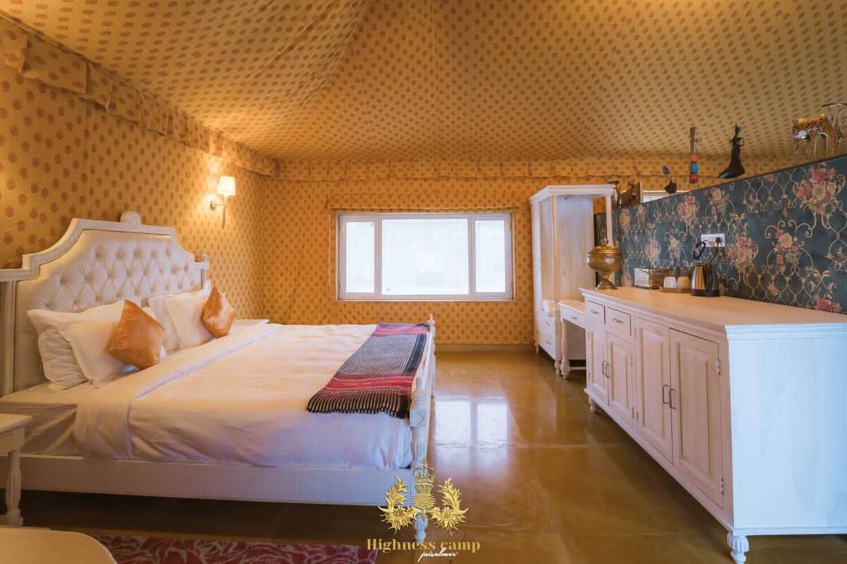 Un dormitorio amplio con una cama grande, un armario y un tocador con espejo.