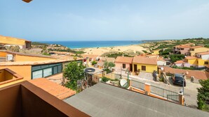 Zona residencial costera con casas, una playa y cielo despejado.