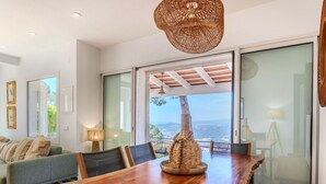 A dining area with a wooden table, chairs, and a woven light fixture. - Stunning private villa for 6 guests with WIFI, private pool, A/C, TV and patio (Lloret De Mar)