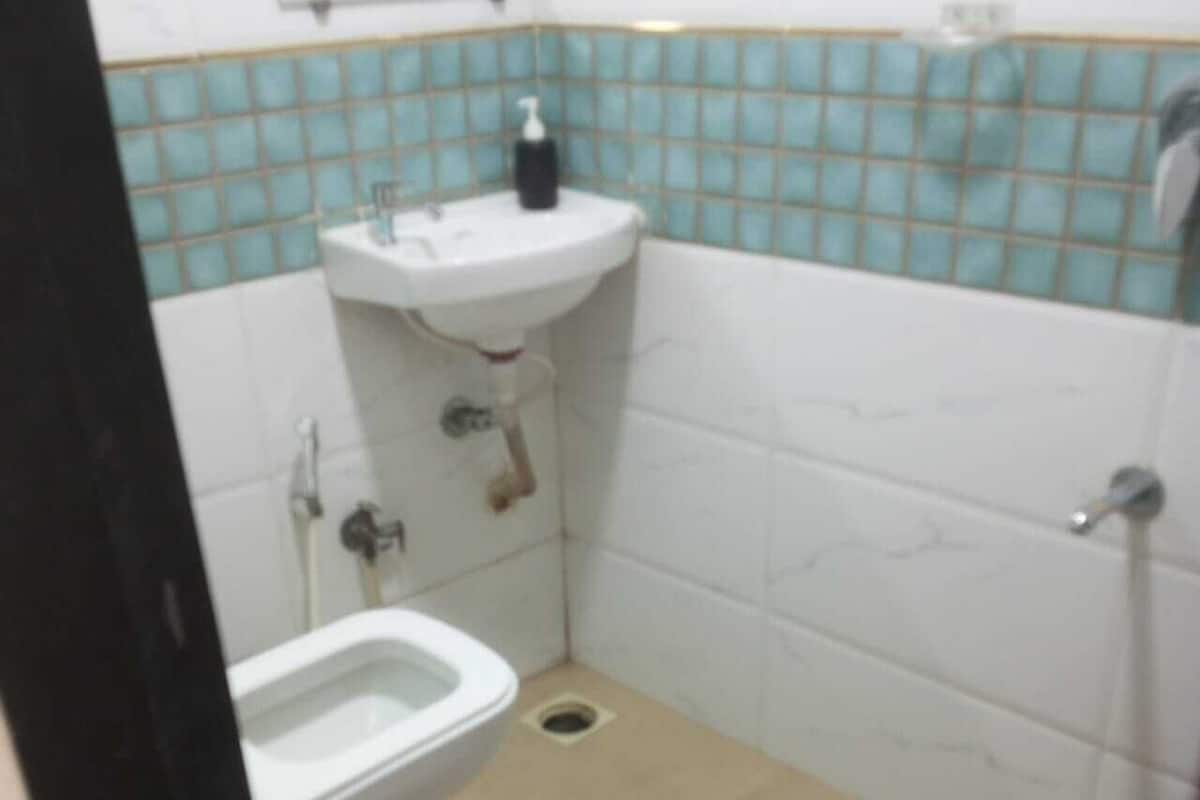 A small bathroom with a toilet, sink, and shower.
