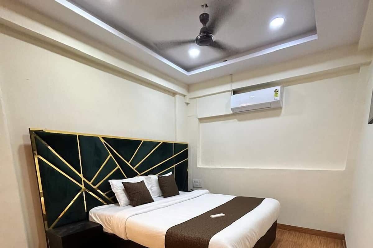 A modern bedroom with a bed, a ceiling fan, and an air conditioning unit.