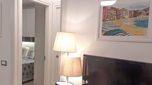 Una habitación con una cama, televisión y una lámpara.