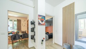A modern living space with a dining area, a bedroom, and a hallway. - Nice apartment for 4 people with A/C, WIFI, TV and balcony (Porto Valtravaglia)
