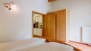 Un dormitorio con dos camas, un armario de madera y un espejo.