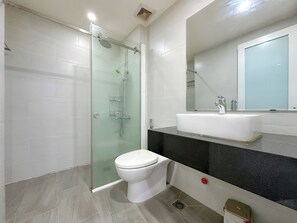 A modern bathroom with a glass-enclosed shower, a white toilet, and a sink with a black countertop. - Siris Lune Residence - Self checkin (Ho Chi Minh City)
