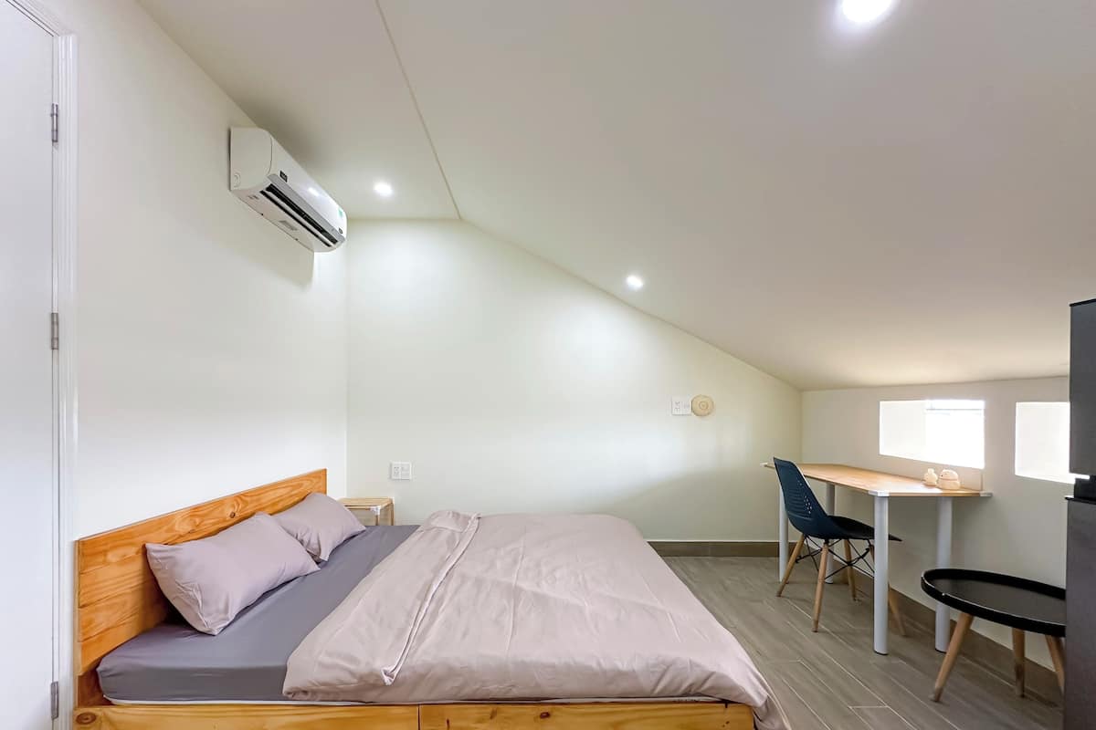 A modern bedroom with a wooden bed, a desk, and a chair.