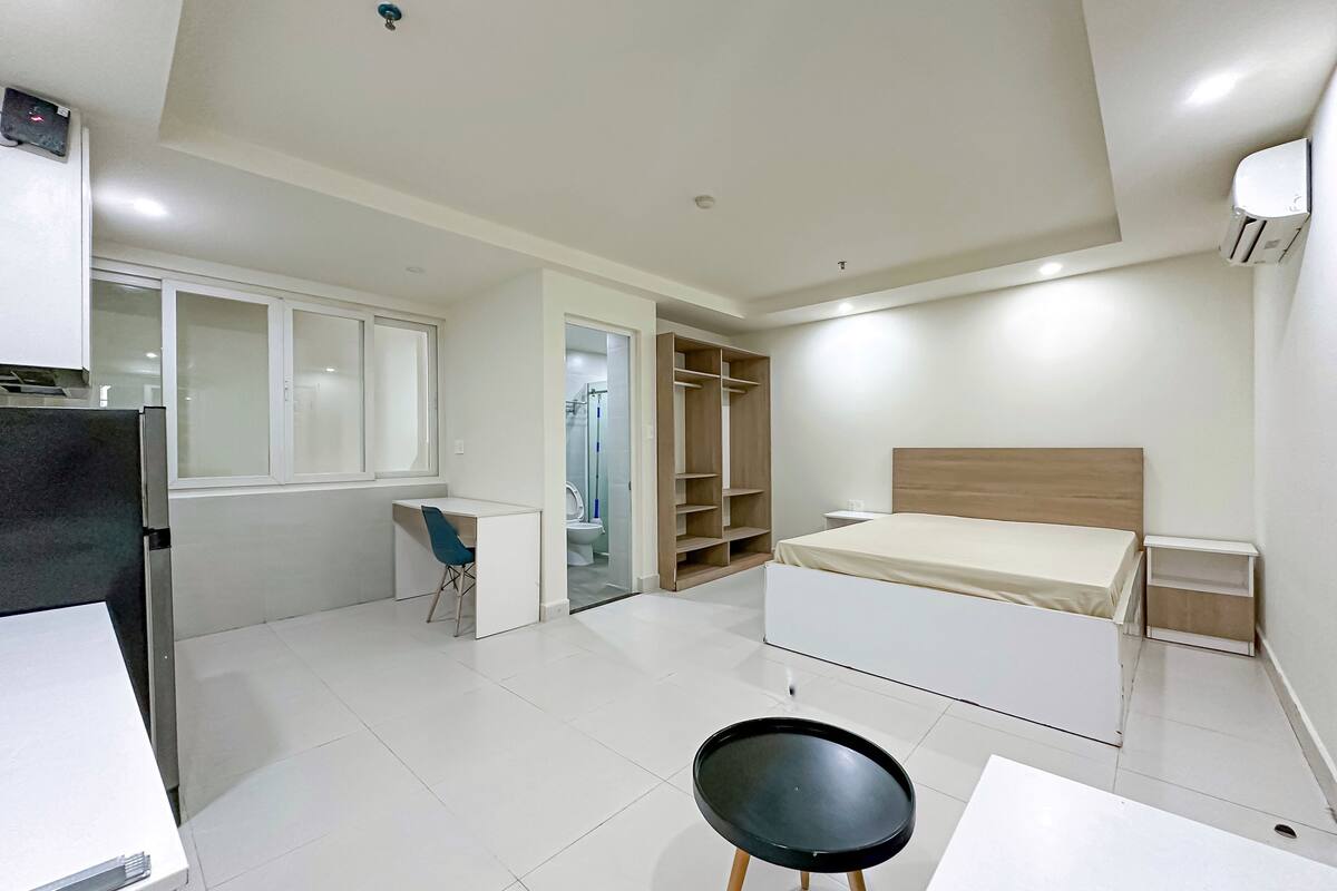 A modern bedroom with a bed, desk, chair, and wardrobe.