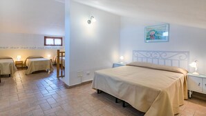 Habitación de hotel con una cama grande, dos mesitas de noche con lámparas, una pequeña mesa con una silla y un cuadro en la pared.