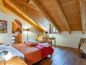 A bedroom with a wooden ceiling, a bed with a red blanket, a chair, a desk, and a lamp. - Beautiful private villa with WIFI, private pool, TV, patio, pets allowed and panoramic view (Tione Di Trento)