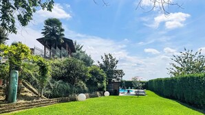 A well-maintained lawn with a small pool area, surrounded by lush greenery and a stone wall. - Nice apartment for 4 people with WIFI, pool, A/C, terrace, pets allowed and panoramic view (Portacomaro)