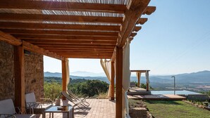 A covered outdoor seating area with a pool and a view of distant mountains. - Beautiful private villa for 10 guests with private pool, WIFI, terrace and pets allowed (Roccastrada)
