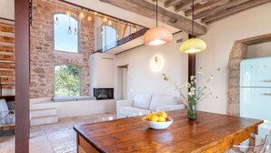 A spacious living area with a wooden dining table, a bowl of fruit, and a modern kitchen with a vintage-style refrigerator. - Beautiful private villa for 10 guests with private pool, WIFI, terrace and pets allowed (Roccastrada)