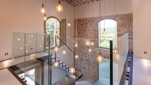 A modern interior with a staircase, glass railings, and exposed wooden beams. - Beautiful private villa for 10 guests with private pool, WIFI, terrace and pets allowed (Roccastrada)