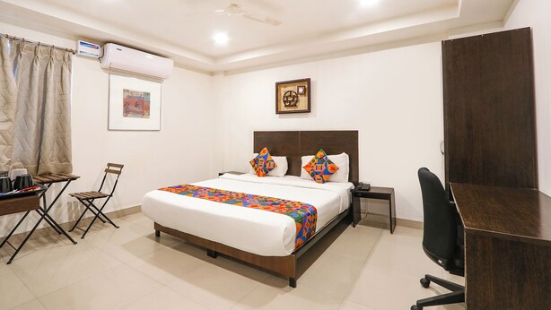 Une chambre d’hôtel équipée d’un lit, d’un bureau, d’une chaise et d’un appareil de climatisation.