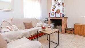 A living room with a sofa, a coffee table, a fireplace, and decorative plates on the wall.