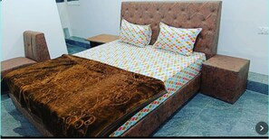 Restful retreat with a large bed, tufted headboard, and patterned bedspread, flanked by two nightstands.