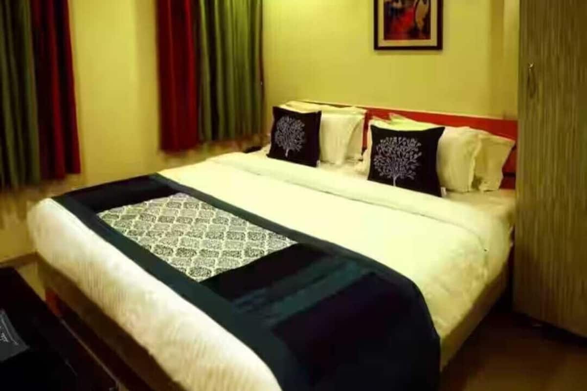 Una habitación de hotel con una cama, un escritorio y un cuadro en la pared.