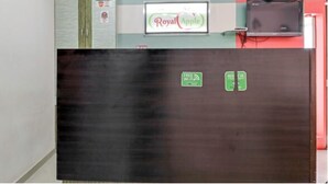 A dark wooden cabinet with a sign for 'Royal Apple' and a 'Free Wi-Fi' sign. - Hotel Royal Apple (Ahmedabad)