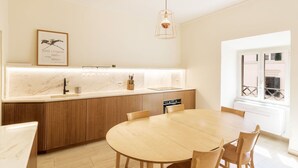 A modern kitchen with a wooden island, white marble countertop, and a hanging light fixture. - Lovely apartment for 4 guests with A/C, WIFI (Rome)