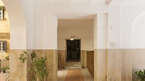 A clean, modern building entrance with a tiled floor and potted plants. - Lovely apartment for 4 guests with A/C, WIFI (Rome)