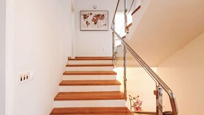 Un escalier avec des marches en bois et une rampe en verre.