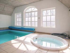 A swimming pool with a hot tub, large windows, and a ceiling with visible beams. - 4 Star Holiday Home in Ulfborg (Ulfborg)