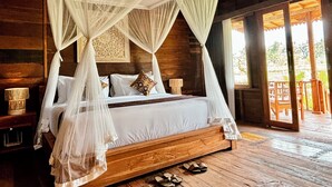 A four-poster canopy bed with white linens, wooden headboard, and two nightstands with lamps. - Jagadhita Villas Ubud Bali (Ubud)