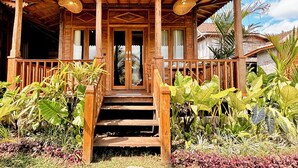 A wooden porch with a staircase leading to a door, surrounded by tropical plants. - Jagadhita Villas Ubud Bali (Ubud)
