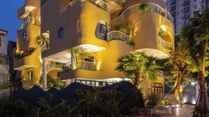A modern building with multiple balconies, outdoor seating, and lush greenery. - Saha Casa Boutique Hotel Da Nang (Da Nang)
