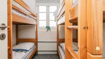 Un dormitorio con literas, una ventana con vistas y una puerta con picaporte.