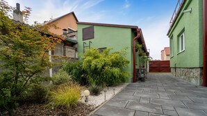 A narrow paved pathway leading to a green building with a small garden area. - Wonderful private villa for 5 guests with WIFI, TV and terrace (Chlumec Nad Cidlinou)