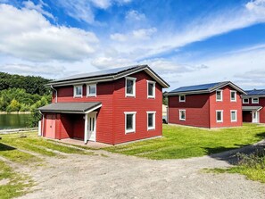 A red building with a flat roof, a small porch, and a door. - Beautiful apartment in villa for 6 guests with WIFI, pool, TV, terrace and pets allowed (Bremervörde)