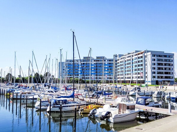 Boats docked in a well-organized marina with modern buildings in the background.