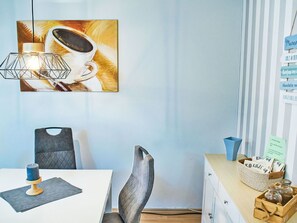 Enjoy a cozy atmosphere in this stylish room with a dining table, comfortable chair, and wall-mounted lamp.