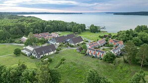 Un quartier résidentiel comprenant plusieurs maisons, un grand plan d’eau et, au loin, une colline boisée.