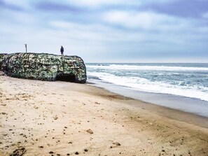 A beach with a large rock formation and the ocean in the background. - 4 Star Holiday Home in Ulfborg (Ulfborg)