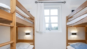 A room with two bunk beds, a window with curtains, and wall-mounted reading lights. - 4 Star Holiday Home in Ulfborg (Ulfborg)