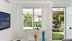 Un salon moderne doté d’une grande fenêtre, d’un coin repas et offrant une vue sur un jardin.