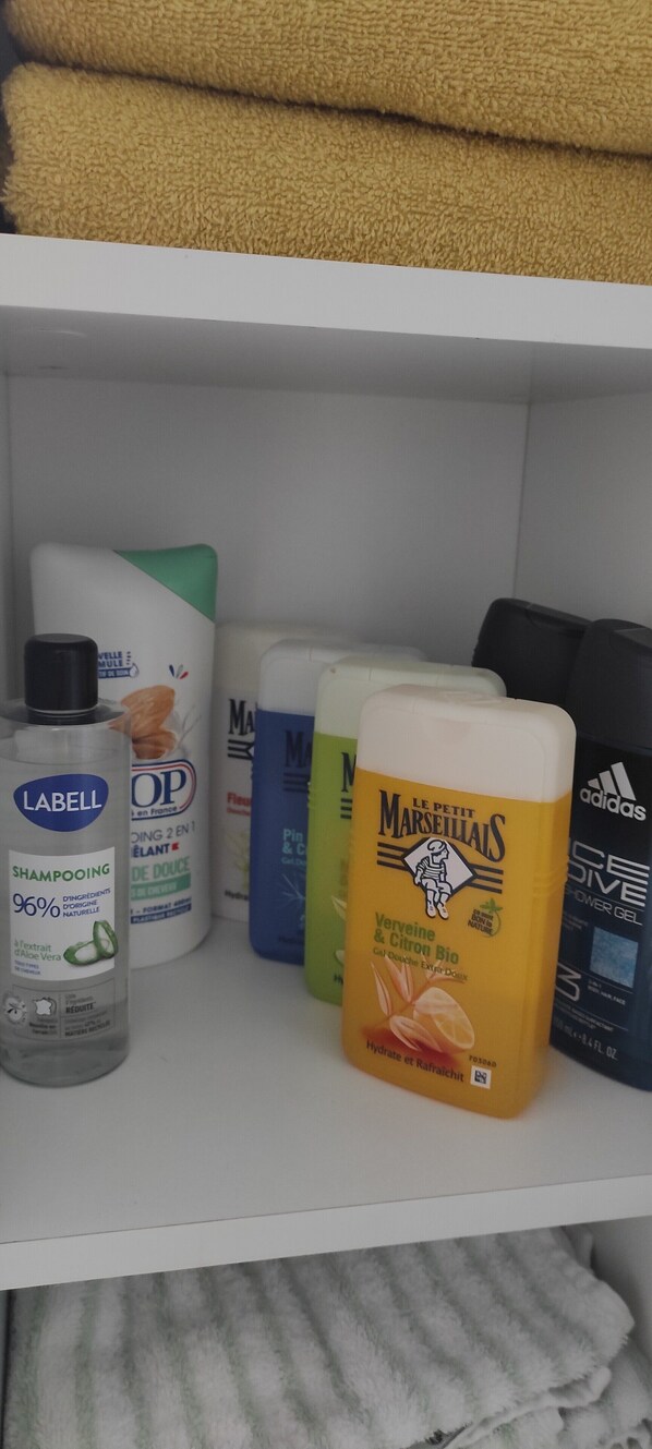 Estante con varios productos para el cuidado del cabello, incluyendo champús y acondicionadores.