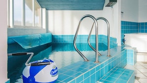 Ein Pool mit Stufen, einem Liegestuhl am Pool und einem Poolreiniger.