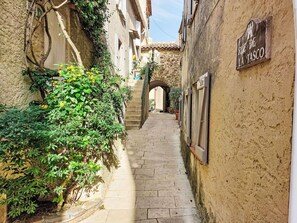 Un estrecho callejón con paredes de piedra y un cartel que dice 'RUE DE LA TASCO'.