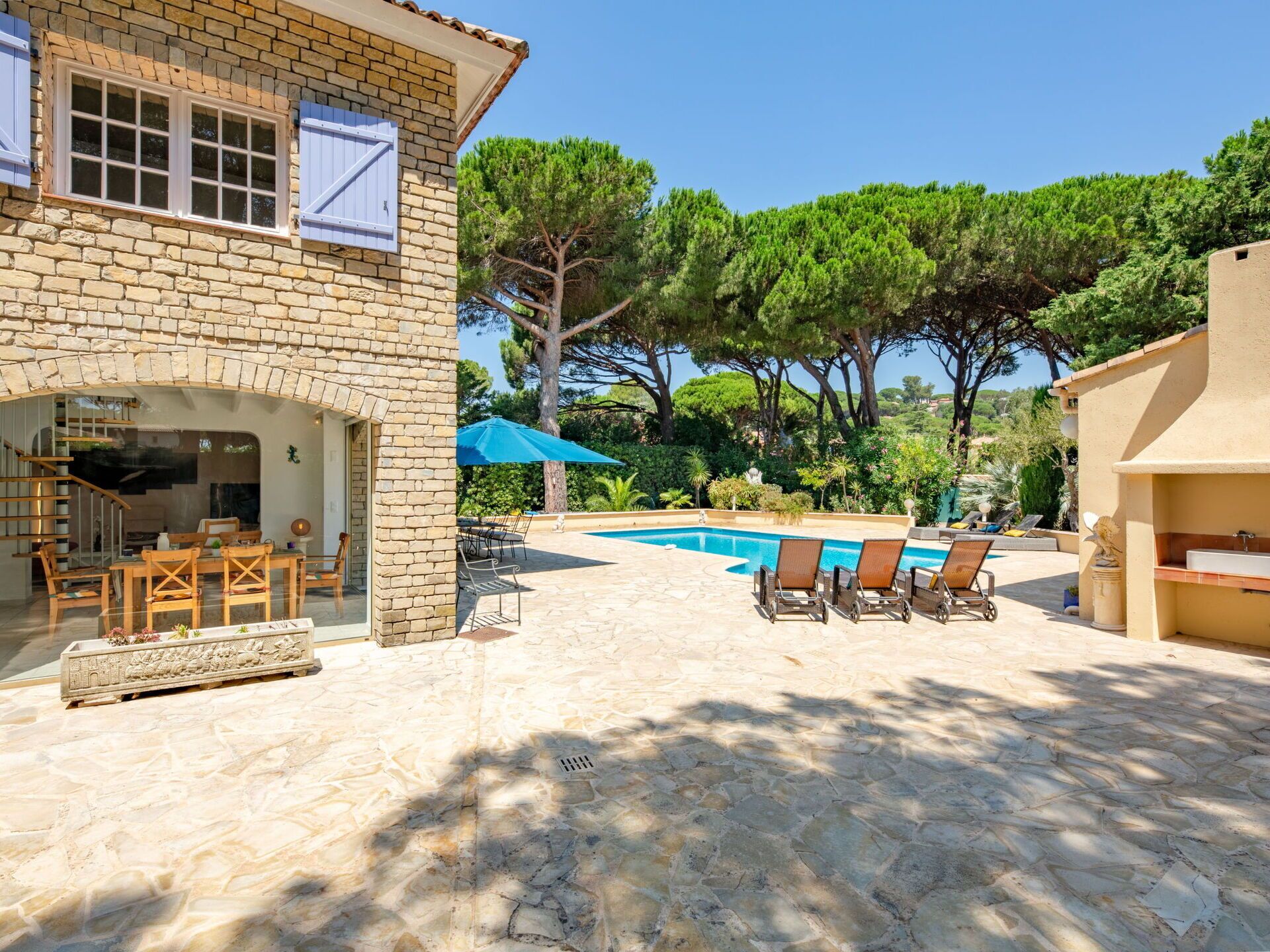 A stone building with a pool, outdoor seating, and a staircase.