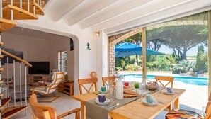 A dining area with a table and chairs, a staircase, and a view of a swimming pool. - Beautiful private villa for 9 guests with WIFI, private pool, A/C, TV and terrace (Sainte-maxime)