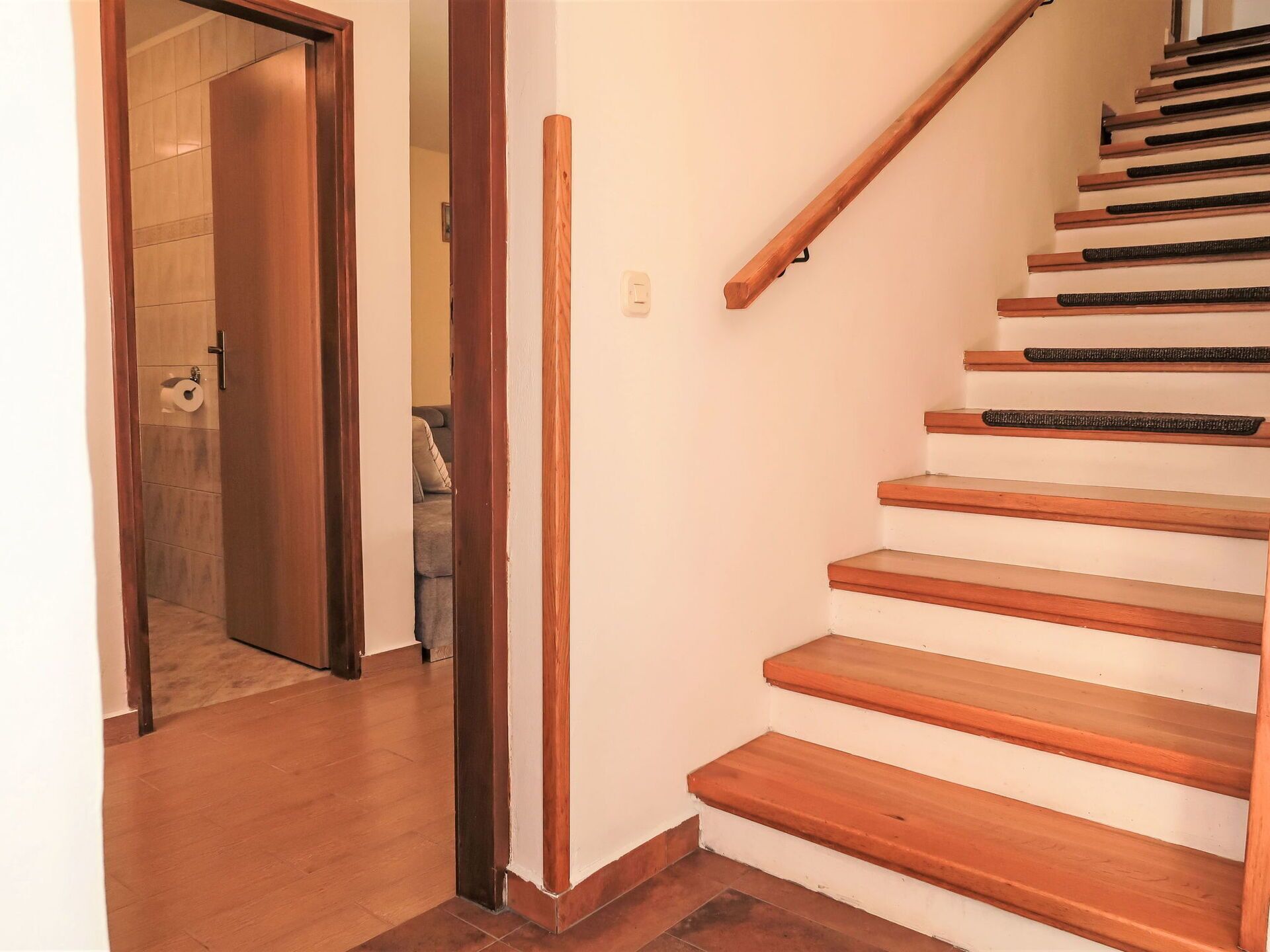A wooden staircase with white risers and a handrail.