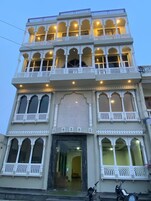 Un edificio de varios pisos con balcones y ventanas arqueadas, que presenta elementos arquitectónicos tradicionales.