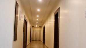 A long, well-lit hallway with wooden floors and doors on both sides. - Hotel Saif Ranthambore (Sawai Madhopur)