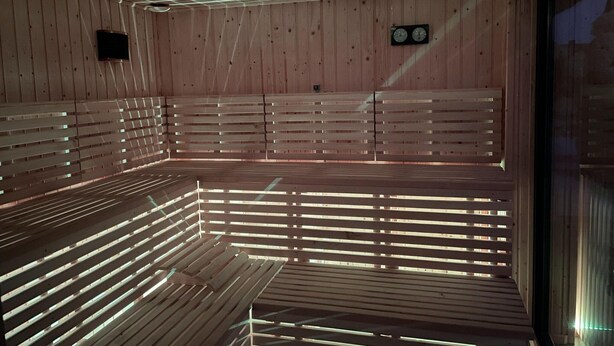 A sauna with wooden benches and a ceiling with embedded lights. - Holiday Homes Very Close to the Beach (Ustronie Morskie)