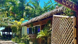 A tropical resort entrance with a wooden sign reading "Welcome to Treasure Cove." - Treasure Beach Co.  (Carles)